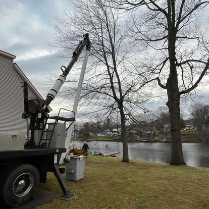 Bucket truck working beside lake — CT waterfront tree removal